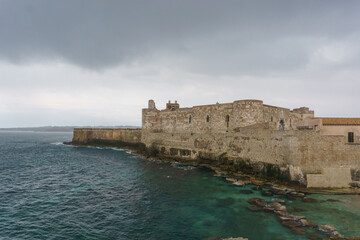 Ancient castle of Maniace at the coast on a cloudy rainy day, Syracuse, Sicily, Italy