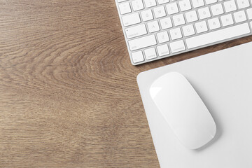 Poster - Computer mouse with mousepad and keyboard on wooden table, flat lay. Space for text