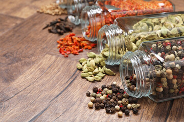 Wall Mural - Different spices in glass jars on wooden table, space for text