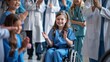 © sirisakboakaew - A young girl in blue scrubs, sitting in her wheelchair being celebrated in the style of medical staff clapping and smiling at the hospital with doctors standing behind them.