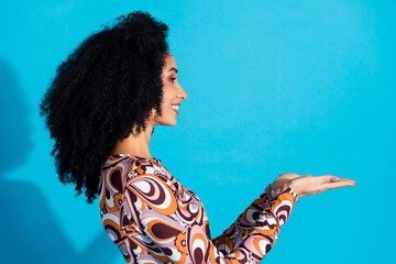 Poster - Photo of lovely adorable woman nice wear trendy print clothes hold empty space isolated on blue color background