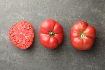 Canvas Print - Whole and cut ripe red tomatoes on grey table, top view