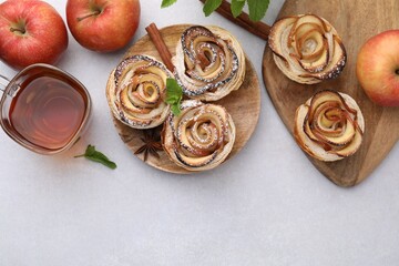 Canvas Print - Freshly baked apple roses, ingredients and tea on light table, flat lay. Space for text