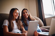 © StarDweller/peopleimages.com - Woman, teenager and technology in living room for streaming, e learning and bonding as family. People, happiness and internet for education, development and homework as mother and daughter in home