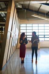 Canvas Print - Business people, coffee and walking in office for collaboration, research and planning project together. Startup, discussion and creative women with company partnership in workplace for media agency