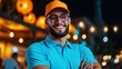 © Vee - Cheerful young man with glasses and a cap smiling brightly in a lively night setting with warm, glowing lanterns.