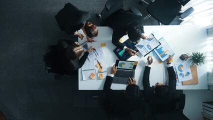 Wall Mural - Top down aerial view of manager standing and present marketing plan to skilled investor. Diverse business team working together to analyze financial statistic graph at meeting table. Directorate.