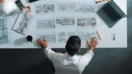 Poster - top view of skilled civil engineer sitting and writing idea while looking at house model. aerial vie
