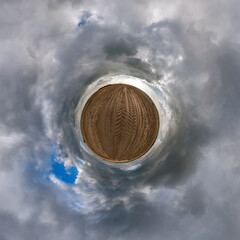 simple little tiny planet without buildings in blue sky with beautiful clouds. Transformation of spherical panorama 360 degrees. Spherical abstract aerial view. Curvature of space.