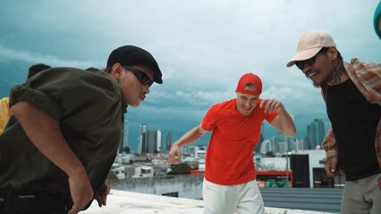 Wall Mural - Caucasian hipster walking while dancing together at rooftop with city view. Multicultural dancer practicing street dance at cityscape or sky scrapper. Street dancing. Outdoor sport 2024. Hiphop.