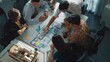 © InfiniteFlow - Group of diverse team planning strategy while sitting at table with project plan. Top aerial view of smart business people working together to brainstorm and design house construction. Alimentation.