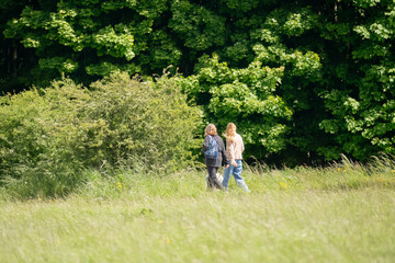 two ladies walking a dog in countryside