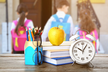 Canvas Print - School stationery with apple, eyeglasses and alarm clock on table against white background