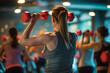 © AnNew - Ftness instructor leading a heart-healthy exercise class in a gym, participants holding small red dumbbells
