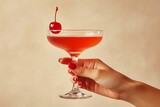 a vintage retro female hand holding a cocktail isolated on a plain background, 1960s and 70s style