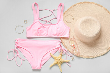 Wall Mural - Composition with stylish swimsuit, hat, sunglasses, accessories and starfish on light background