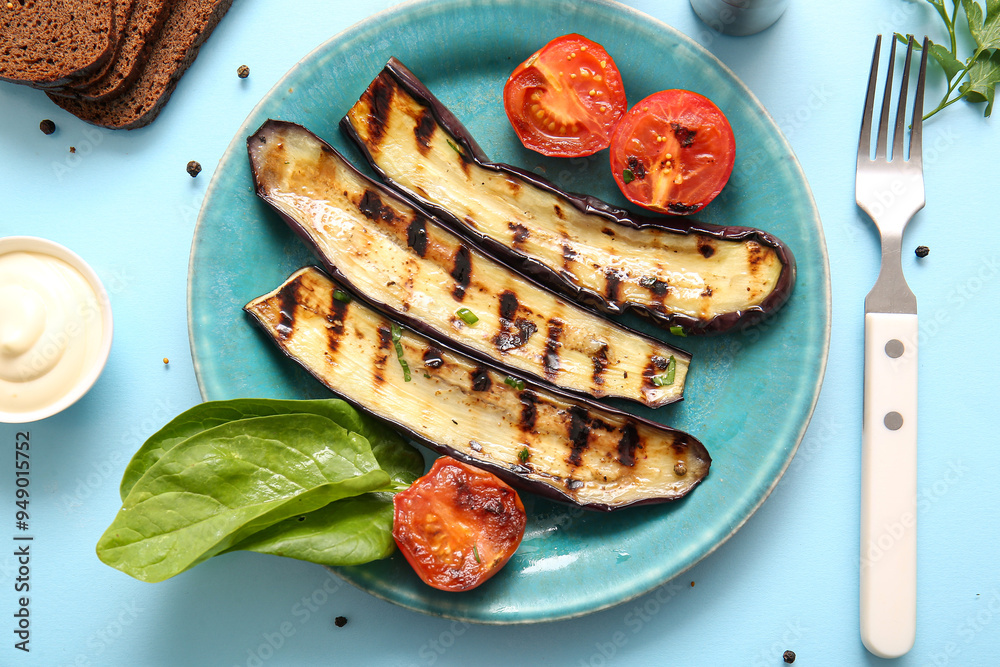 Plate with delicious grilled eggplants and tomatoes on light blue background