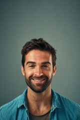 Poster - Happy, smile and portrait of man in studio with positive attitude, confidence and pride. Handsome, attractive and isolated person with joy, cheerful and excited expression on gray background