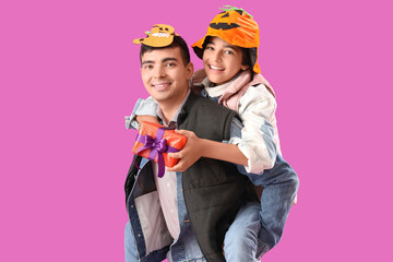 Poster - Little boy with his father and Halloween gift on purple background