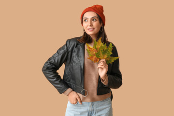 Sticker - Beautiful young woman with autumn leaves on brown background