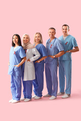 Poster - Professional team of doctors with red ribbons on pink background. World AIDS Day concept