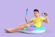 © Pixel-Shot - Cute little happy boy with inflatable ring and snorkeling mask on purple background