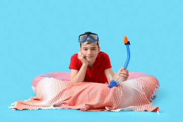 Wall Mural - Cute little boy with inflatable ring and snorkeling mask on blue background