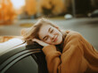 © Zhongyuan Chen - A young woman rests her head gently on the bonnet of her beloved car, smiling warmly with eyes closed. Her expression shows tenderness and joy, revealing deep affection.