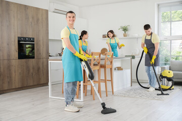 Poster - Group of young janitors cleaning in kitchen