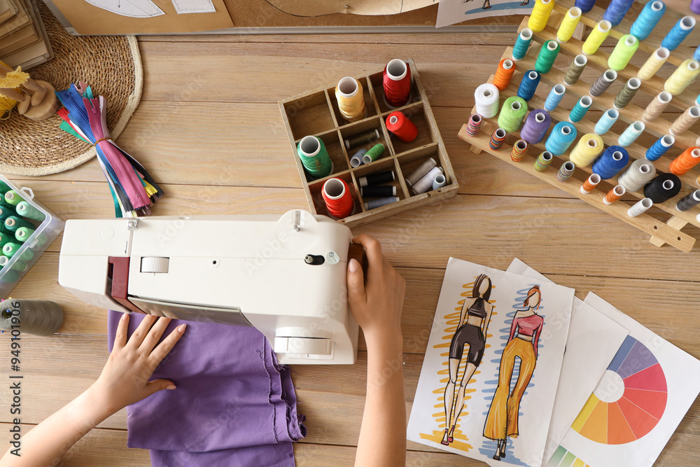 Fashion designer sewing clothes on wooden table, top view