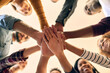 © FotoPush/peopleimages.com - Happy, people and hands together with motivation, commitment and smile from below for teamwork. Diversity, closeup and collaboration with group huddle to show solidarity, trust and bonding with care