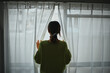 © beeboys - カーテンから外の風景を見る女性の後姿