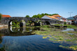 © Lpsnoops - Ponte Românica sobre o Rio Anços na Redinha, Pombal, Portugal - Património Histórico e Paisagem Natural. A ponte com arcos de pedra bem preservados, reflete-se na água calma do rio.