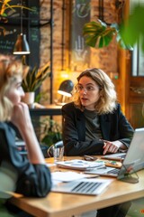 Poster - Two females sitting at a desk with open laptops, likely working or studying