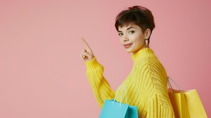 Full body portrait of a woman with short hair, yellow sweater, shopping bags, pointing to the side, pastel pink backdrop, copy space.