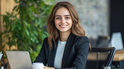 Poster - Confident young businesswoman in a sleek office suit sitting at a desk with a laptop and coffee cup, 