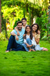 © StockImageFactory - Happy Indian family of four sitting in park, embracing and smiling at camera, enjoying quality time