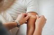© KayExam/peopleimages.com - Hands, arm and woman with bandage for kid in home bedroom for wellness or healthcare. Family, first aid and mother apply bandaid plaster on hurt or injured child for injury or medical injection