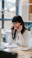 Poster - A woman is talking on the phone while sitting at a desk