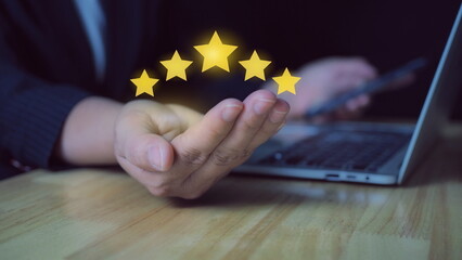 Wall Mural - hand of customer or client holding the stars to complete five stars. with copy space. giving a five star rating. Service rating, satisfaction concept.