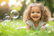 © mat - Emotion kid. Joyful child blowing bubbles in a sunny park.