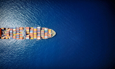 High aerial top down view of a large container cargo ship in motion over open ocean as a banner with copy space