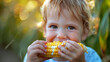 © Sana Sabina - Close-up of a cute 3-year-old child eating yellow corn on the cob.