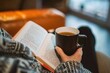 © alisaaa - Reading and Relaxing Over the shoulder view of a unrecognisable person reading and holding a hot drink while indoors.