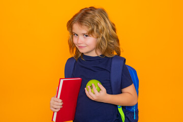Fototapete - School kids. School boy with book, isolated on yellow studio background. Funny little boy from elementary school with book. Education and knowledge. Back to school.