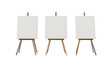 © Daniel - Three blank canvases on easels in a white room with natural light.