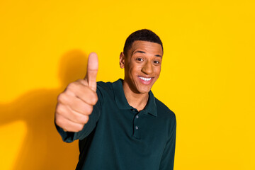 Wall Mural - Portrait of nice young man thumb up wear pullover isolated on vibrant yellow color background