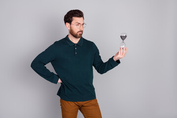 Wall Mural - Photo of successful handsome man wear stylish green clothes hold sand glass isolated on gray color background