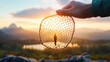 © MAY - A hand holding a safety net with a person standing safely within it, representing the financial protection offered by insurance.