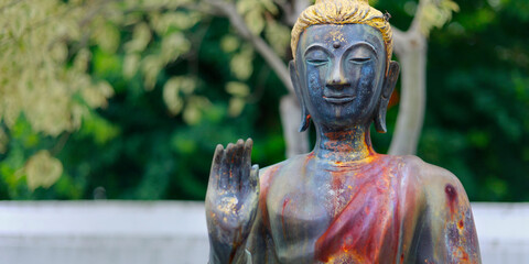 head of statue of buddha, in the garden of buddhist temple 